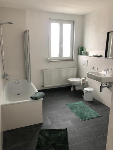 a bathroom with a tub and a toilet and a sink at Ländliche Fewo Rose, 4km zum Stausee in Happurg