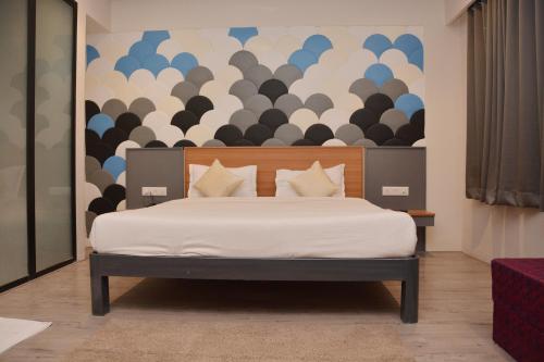 um quarto com uma cama com uma grande parede em Hotel Sai Palki Niwara em Shirdi