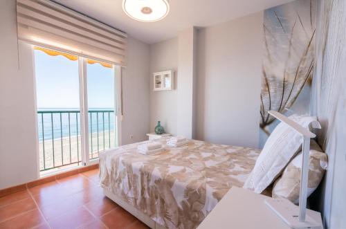 - une chambre avec un lit et une vue sur l'océan dans l'établissement Apartamento junto al mar en costa tropical y Alpujarras granadinas, à Melicena