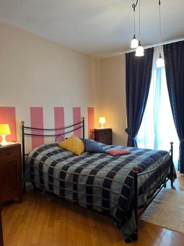 a bedroom with a bed with a plaid blanket at Tuscan Room in San Quirico dʼOrcia