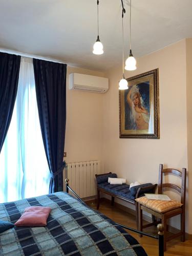 1 dormitorio con 1 cama, 1 silla y 1 ventana en Tuscan Room en San Quirico dʼOrcia
