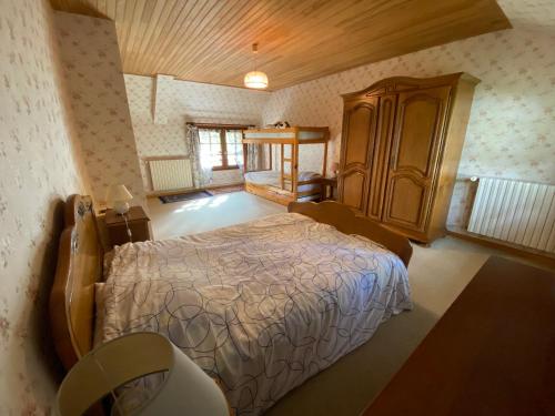a bedroom with a bed and a wooden cabinet at Le Val Godard in Fresnay-le-Samson