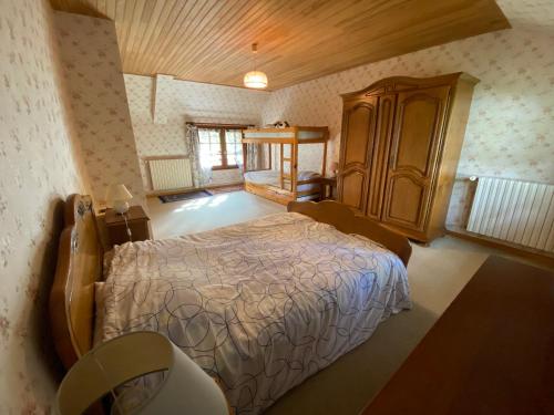 1 dormitorio con 1 cama y armario de madera en Le Val Godard en Fresnay-le-Samson