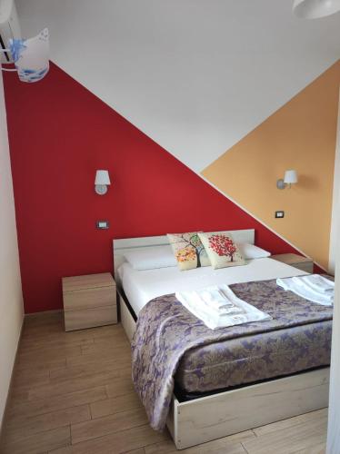 a bedroom with a bed and a red wall at B&B Lara Santola in Corato