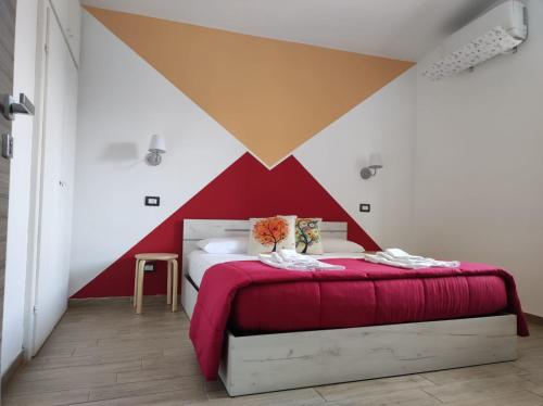 ein Schlafzimmer mit einer roten und weißen Wand in der Unterkunft B&B Lara Santola in Corato