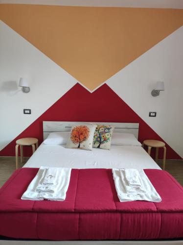 a bedroom with a bed with a red and white wall at B&B Lara Santola in Corato