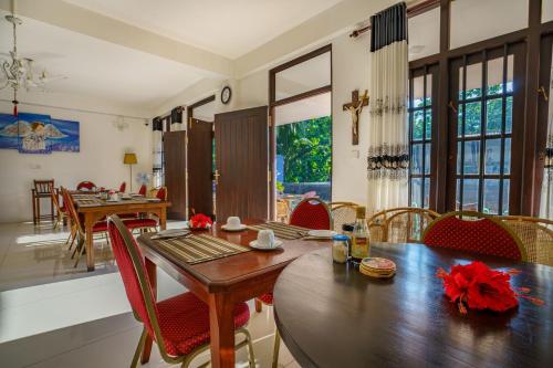 a dining room with a wooden table and chairs at Abundia Unawatuna in Unawatuna