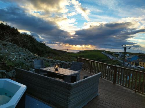 a patio with a table and chairs on a deck at Luxury Lodges in Doolin Village with Hot Tubs in Doolin