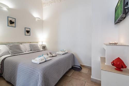 a bedroom with a bed with towels on it at Vico di Ostuni Apartments by Rentbeat in Ostuni