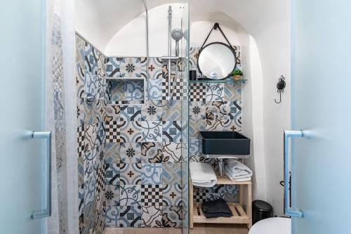 a bathroom with a shower with blue and white tiles at Vico di Ostuni Apartments by Rentbeat in Ostuni