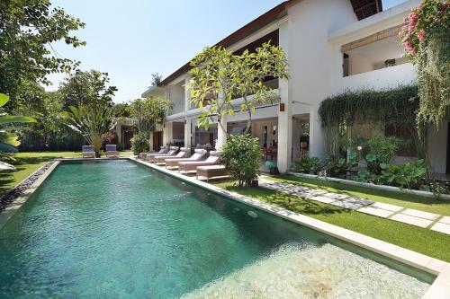 a swimming pool in front of a house at Villa Bali Asri Batubelig in Seminyak