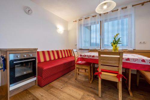 a kitchen and dining room with a table and a couch at Maurerhof Abendrot in Maranza