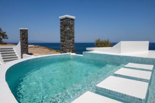 a swimming pool with the ocean in the background at Grand Village in Imerovigli