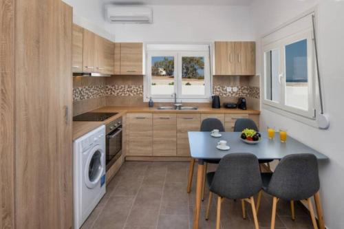 a kitchen with a blue table and chairs in a kitchen at Grand Village in Imerovigli