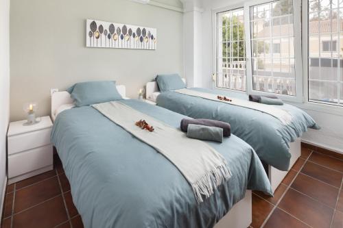two beds in a room with two windows at Apartment Los Olivos Heated Pool in Rincón de la Victoria