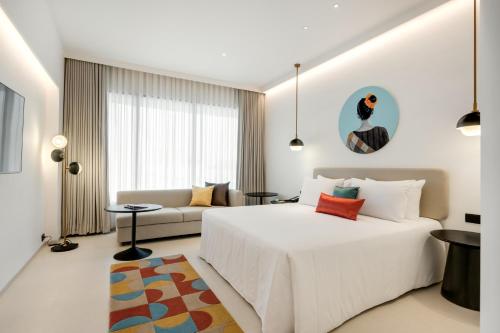 Un dormitorio con una gran cama blanca y un sofá. en Greenpark Bengaluru, en Bangalore