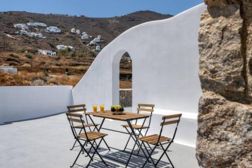 a table and chairs on a patio with a view at Grand Village in Imerovigli