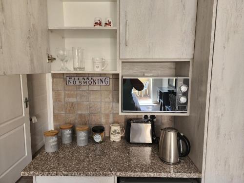 a kitchen with a counter top with a no smoking sign at Schnehage Self Catering in Bloemfontein
