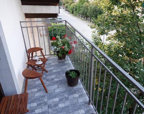 a balcony with a chair and a table and a railing at Pet Omorika in Bajina Bašta