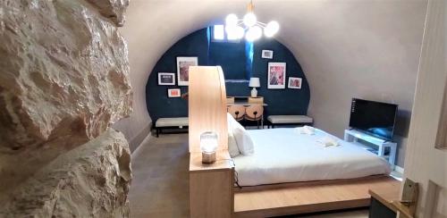 a bedroom with a bed and a rock wall at Mina Boutique in Jerusalem