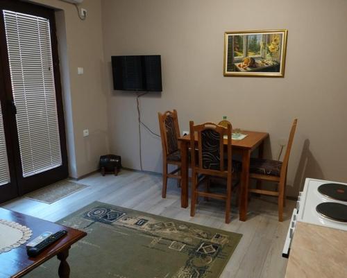 a living room with a table and chairs and a television at Pet Omorika in Bajina Bašta