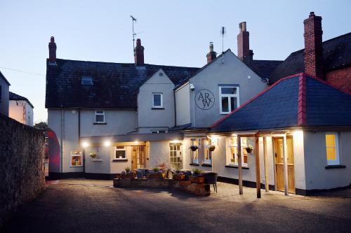 a white building with lights in front of it at The Wallace Steakhouse with Rooms in Usk