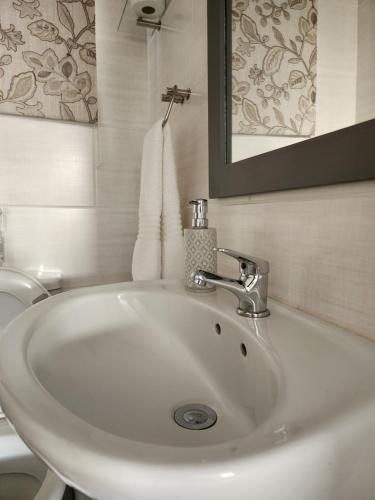 lavabo blanco en el baño con aseo en Schnehage Self Catering, en Bloemfontein