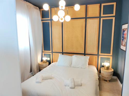 a bedroom with a large white bed with a chandelier at Mina Boutique in Jerusalem