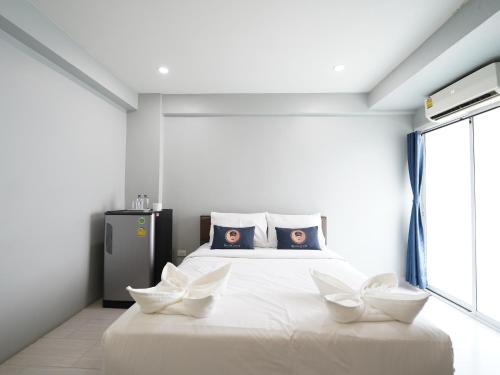 a bedroom with a white bed with two white flowers on it at RoomQuest Bangkok Don Mueang Airport in Bangkok