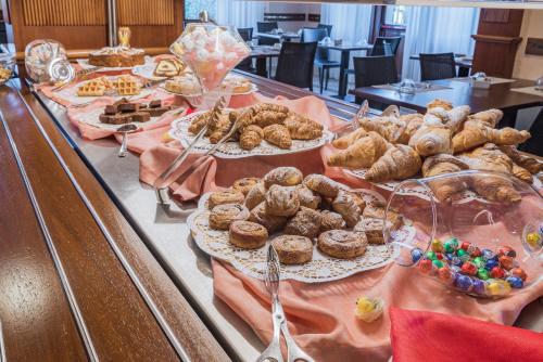 a table with many different types of pastries on plates at Hotel Gardenia Sirmione in Sirmione