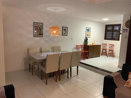 una sala da pranzo e un soggiorno con tavolo e sedie. di Suspiro da Bahia Pé na areia a Salvador
