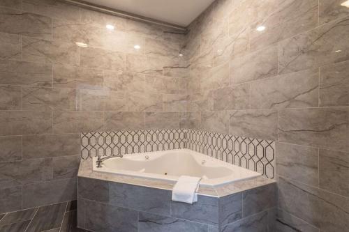 a bathroom with a bath tub in a room at Quality Inn & Suites Pearl-Jackson in Pearl