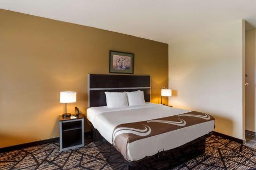 a hotel room with a large bed and two lamps at Quality Inn & Suites Pearl-Jackson in Pearl