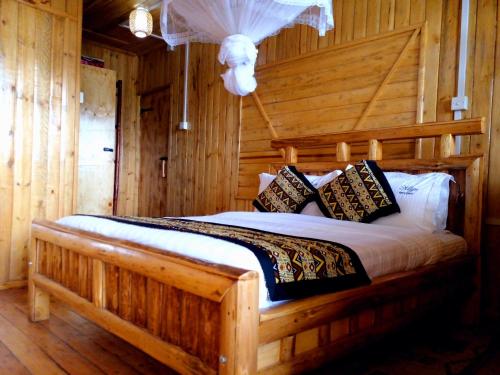 a bedroom with a bed in a log cabin at Keije Resort Bunyonyi in Kabale
