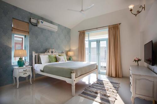 a bedroom with a bed and a television in it at Mediterranean Bliss by VEO - Part of StayVista in Sangolda