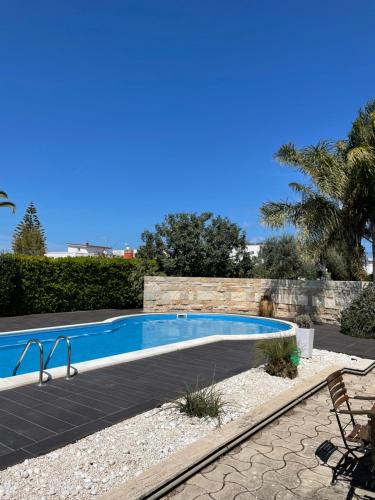 een zwembad in een landschapstuin met een palmboom bij Apulian Way in Torre Pelosa