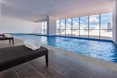 a swimming pool with a view of a building at Wyndham Puebla Angelopolis in Puebla