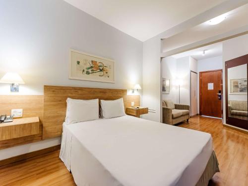 a bedroom with a large white bed in a room at Ibis Styles Campinas Alphaville in Campinas