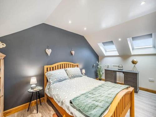 ein Schlafzimmer mit einem großen Bett und zwei Fenstern in der Unterkunft Rita's Roost, Lancs, tranquil with amazing views in Burnley