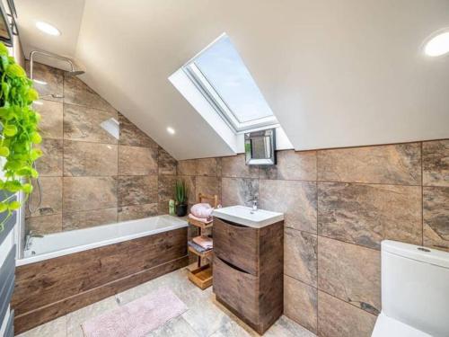 ein Bad mit einem Waschbecken, einer Badewanne und einem Fenster in der Unterkunft Rita's Roost, Lancs, tranquil with amazing views in Burnley