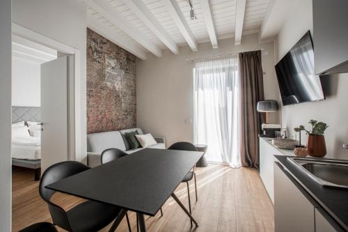 a kitchen and living room with a table and chairs at Ah Villaglori Boutique Apartments in Brescia