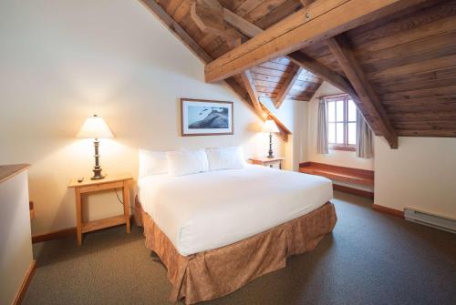 Un dormitorio con una gran cama blanca y una ventana en Painter's Lodge, Trademark Collection by Wyndham, en Campbell River