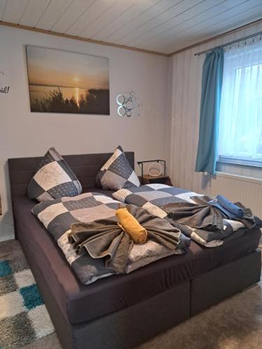 a bed with a blanket on it in a room at Fewo Seerose in Zempin