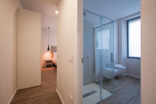 a bathroom with a glass shower and a toilet at Ah Villaglori Boutique Apartments in Brescia