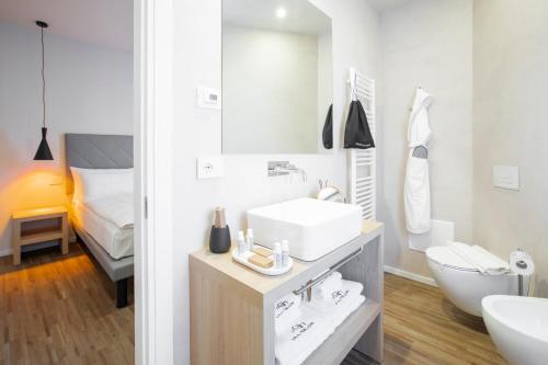 a white bathroom with a sink and a bed at Ah Villaglori Boutique Apartments in Brescia