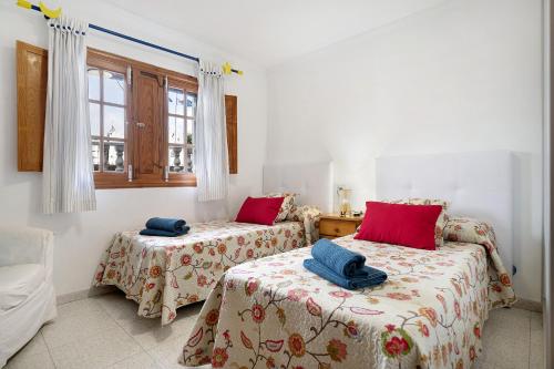two beds in a room with red pillows at Casa Carmen in Puerto del Carmen