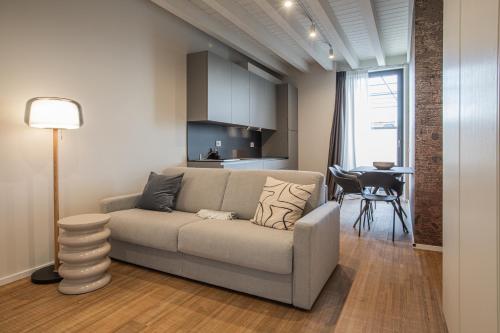 a living room with a couch and a kitchen at Ah Villaglori Boutique Apartments in Brescia