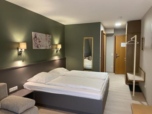 ein Schlafzimmer mit einem großen Bett und einer grünen Wand in der Unterkunft Hotel-Restaurant Zur Mühle in Schermbeck