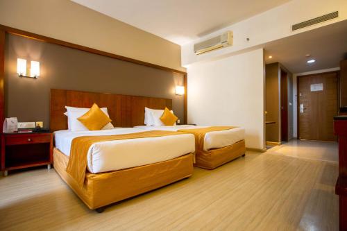 a bedroom with two beds in a hotel room at Evoma in Bangalore