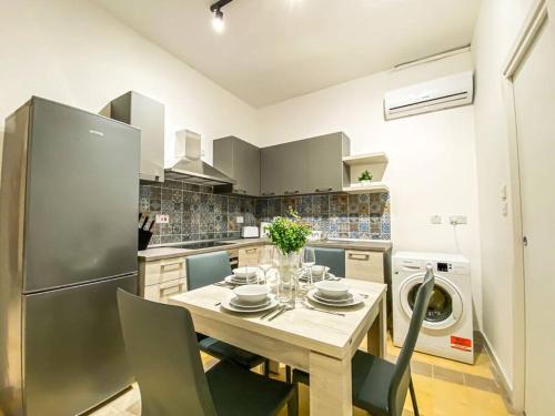 cocina con mesa y nevera en Stylish one bedroom apartment in Gzira 1 en Il-Gżira